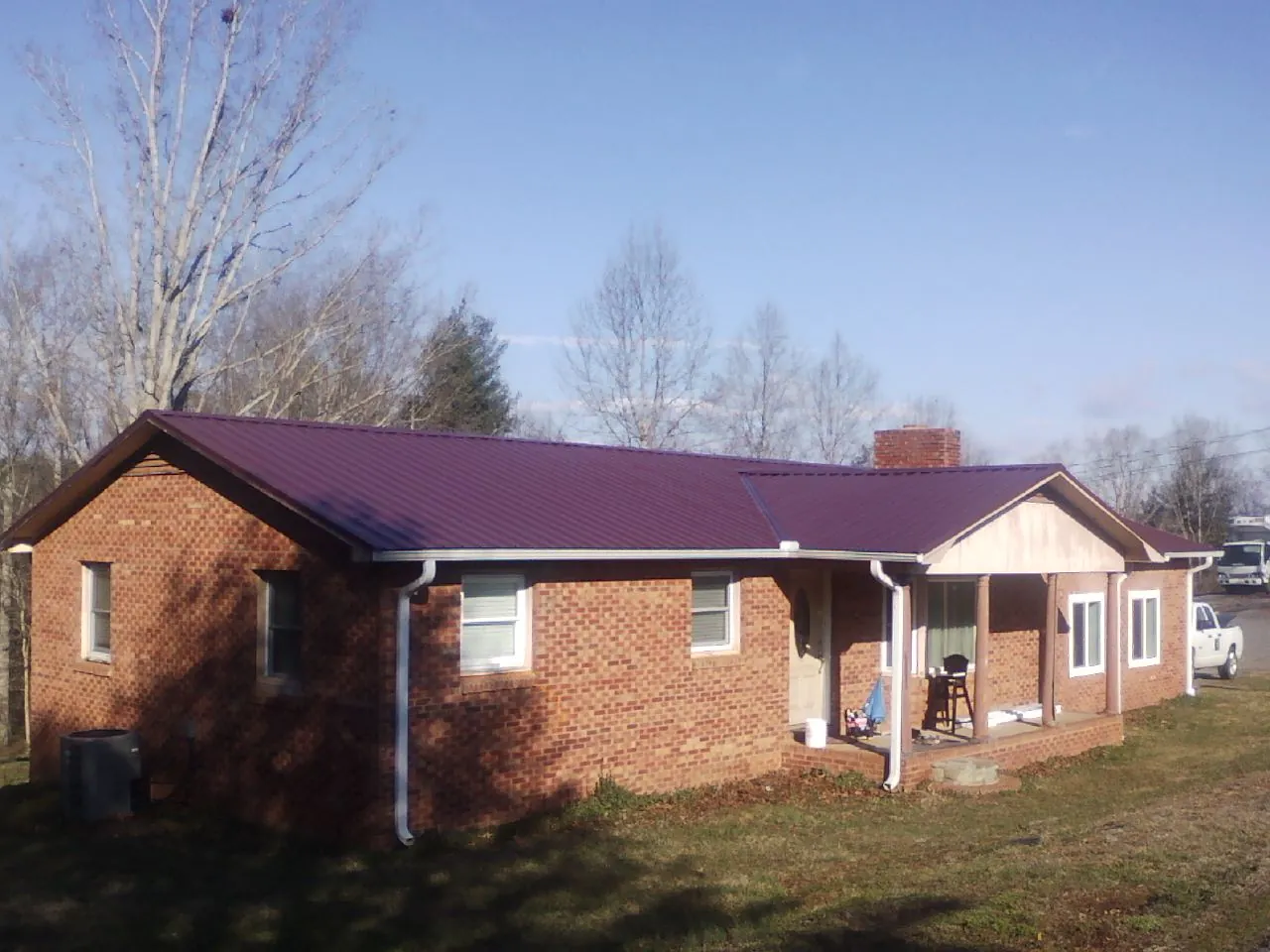 Burgundy metal roof on a brick ranch home with a new addition in Harford