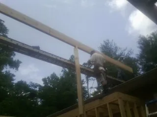 Carpenter setting a ridge beam over a new addition frame — Ice Dam Removal by Roofing Brothers in Harford