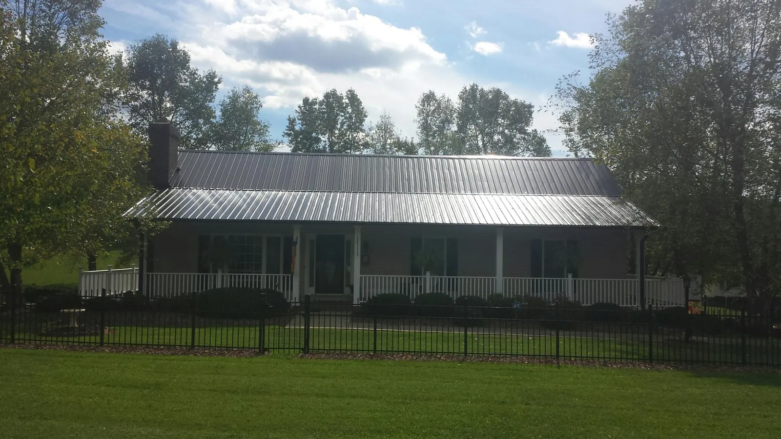 Gray metal roof on a brick ranch with a full width front porch — Gutter Guard Installation work by our crew in Harford