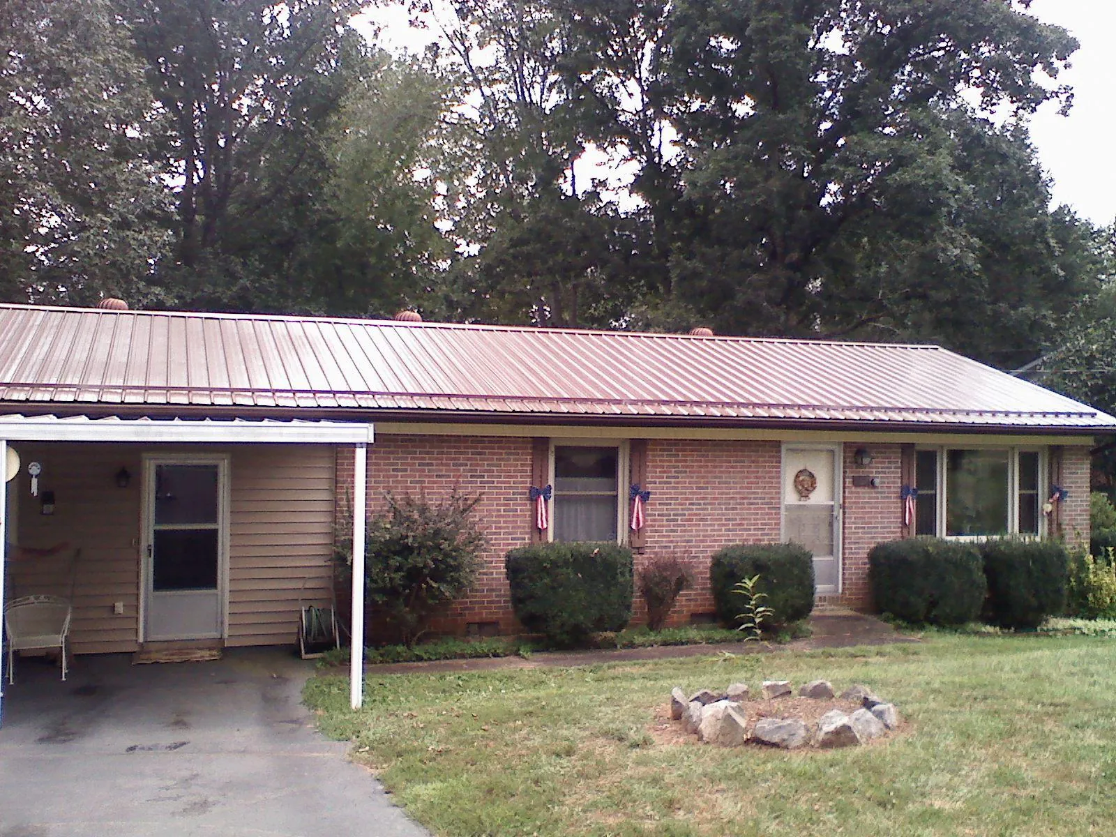 Bronze metal roof and carport on a brick ranch home — Roof Repair work by our crew in Harford